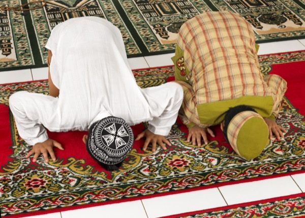 Muslim children praying in a mosque. © Distinctive Images | shutterstock.com