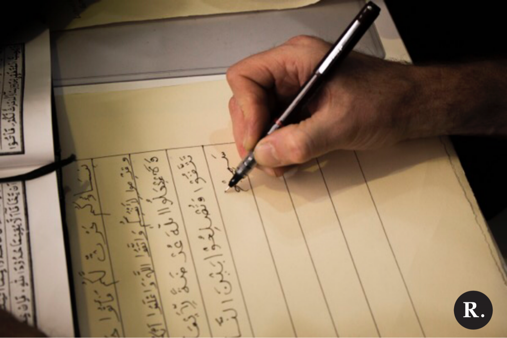 A person writes a verse of the Qur'an for the Al-Qalam Project
